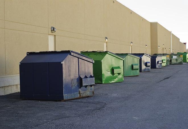 construction workers carrying construction debris to a dumpster in Dearborn